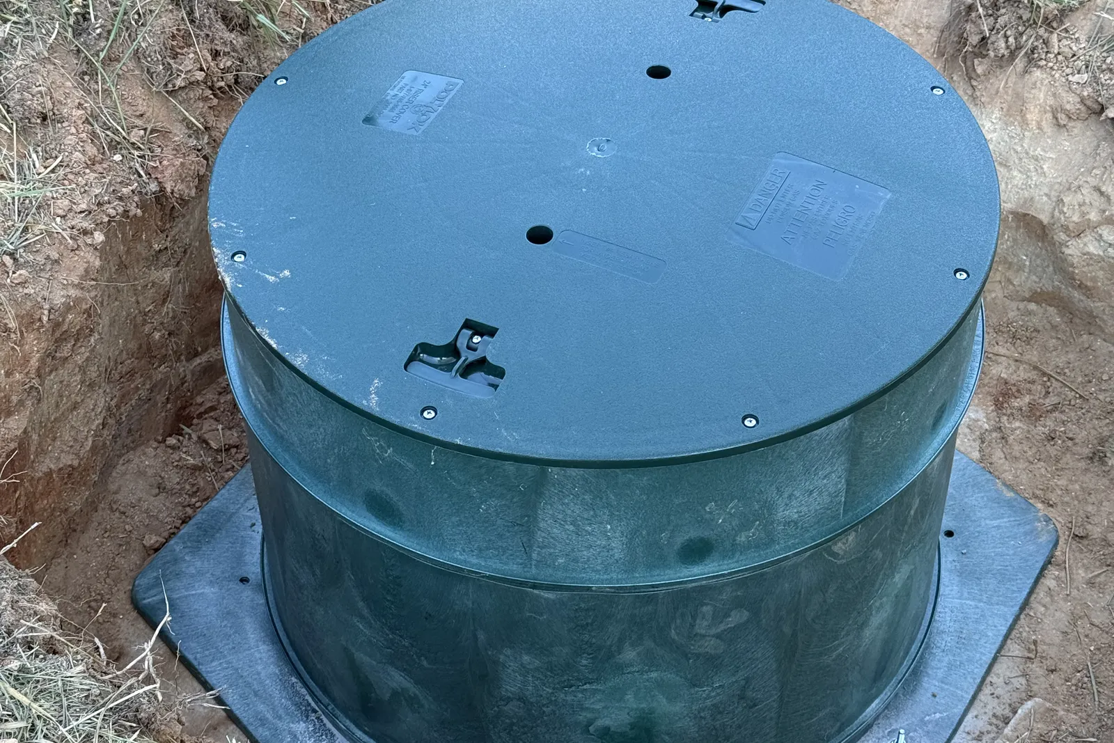 Finished septic tank riser and lid seated on its base plate