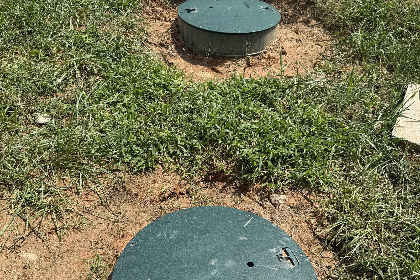 Finished septic tank riser lids set flush with a lawn